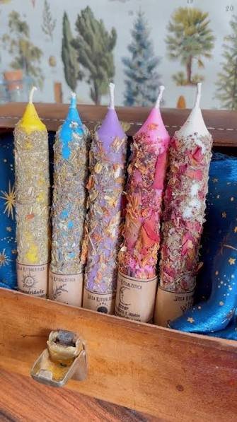 Velas rituales artesanales coloridas decoradas con hierbas y flores